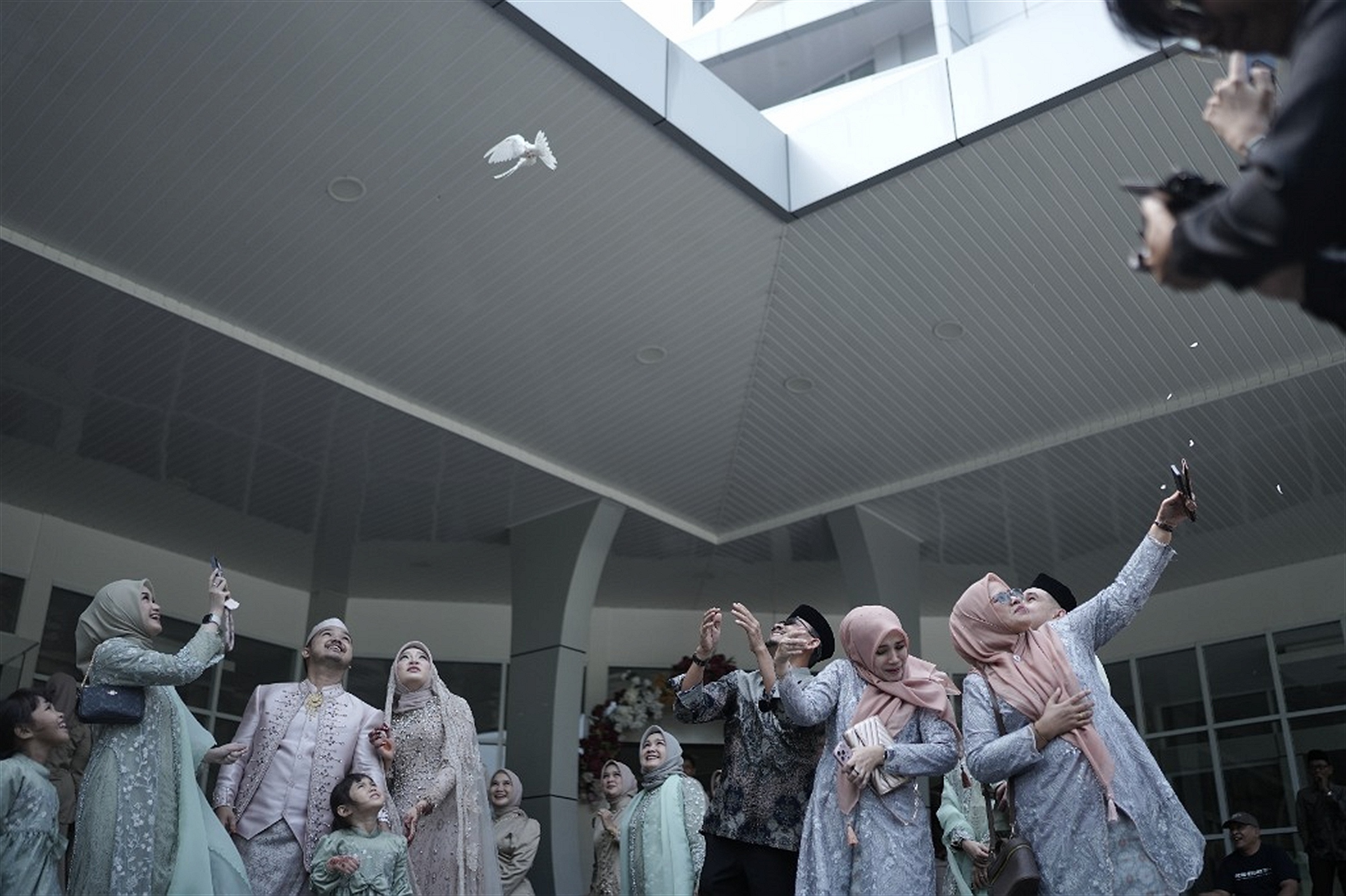 Prosesi pelepasan burung merpati putih bersama keluarga besar di area outdoor auditorium
