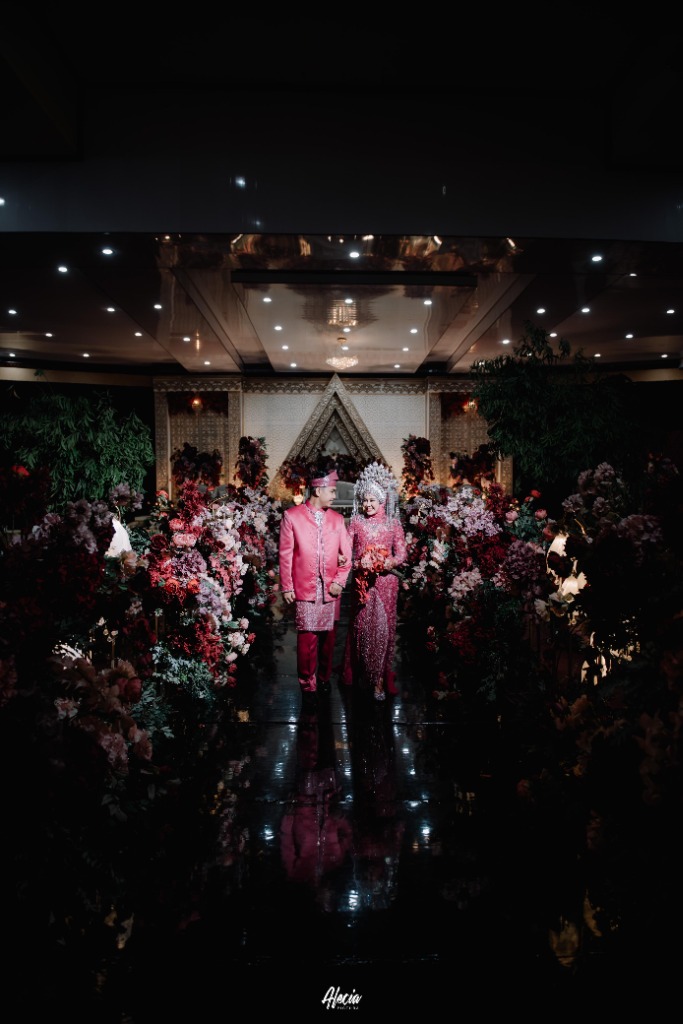 Prosesi melangkah menyusuri grand aisle berkarpet mika hitam di bawah lorong bunga megah Ballroom Hotel Ratu Mayang Garden