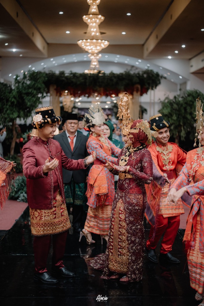 Pertunjukan tarian adat manortor dan alunan musik tradisional yang khidmat memeriahkan pesta pernikahan di ballroom